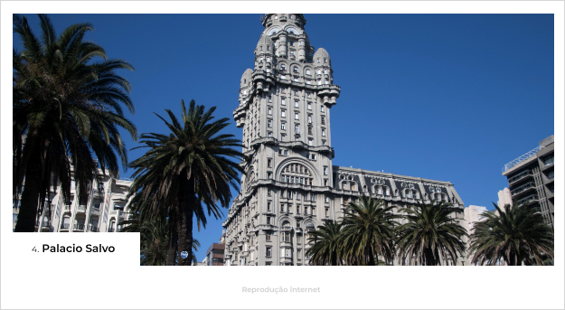 Palacio Salvo cerca por árvores em dia com céu azulPrédios ao redor da avenida 18 de julio - O que fazer em Montevideo, Uruguai - Blog Mundo Lá Fora