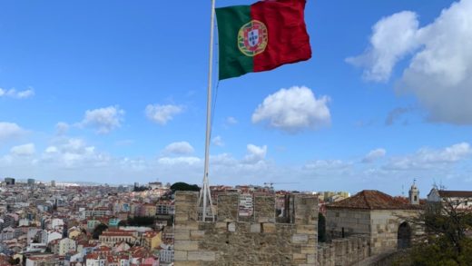 bandeira de portugal ondulando no topo do Castelo de São Jorge, em Lisboa