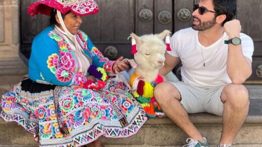 Mulher com roupa típica andina do Peru, uma lhama decorada e home em roupas ocidentais