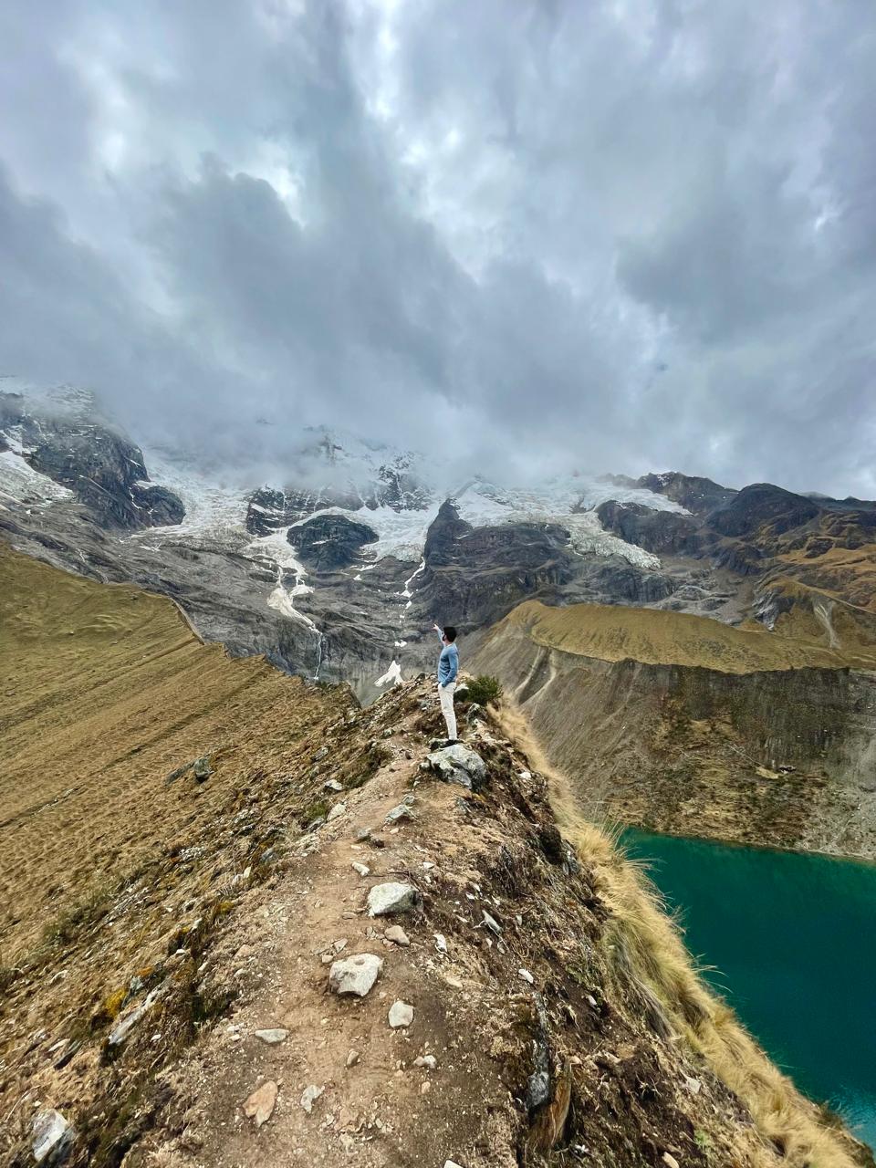 Homem apontando para montanha na Laguna Humantay, Cusco, Peru